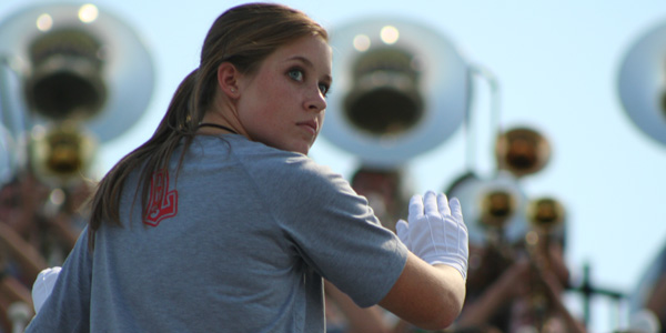 Senior Kristi Kamesch directs the band in song during a football game