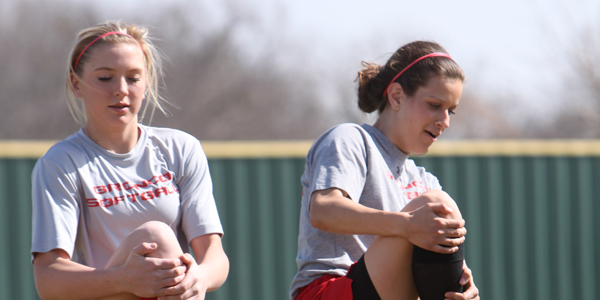 Freshman Reagan Wright and junior Kaitlin Nelson warmup for softball practice.