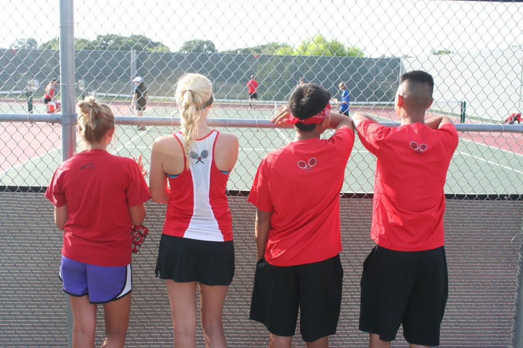 Legacy Tennis players watch an ongoing game in a tournament hosted by Legacy.