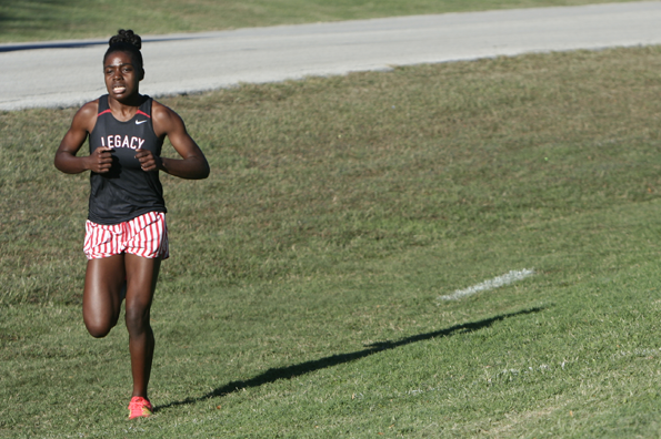 Sophomore Deja Moorehead runs up the steep, grassy hills of the course.