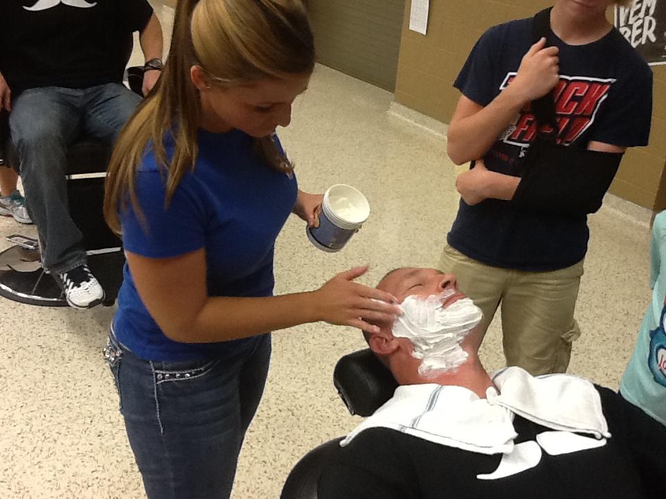 As a part of Movember Fundraiser, Jobe Middle School Coach Troy Harvey gets lathered up by one of the owners of vintage barbershop, Penni Hatton. (Courtesy Photo)