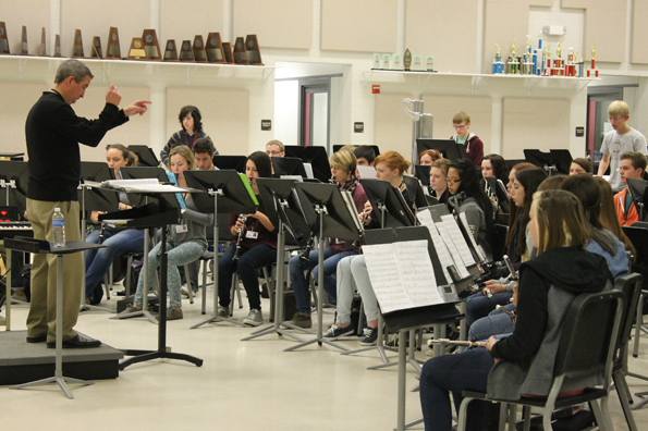 Band Director Glenn Fugett conducts the band as they practice together.