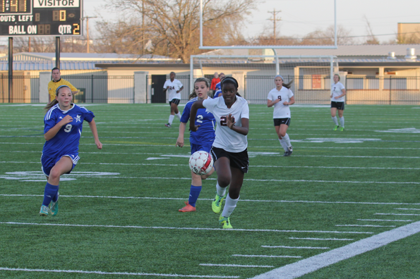 Peyton McGee, 9, kicks the ball across the field in attempt to score against Joshua High School.