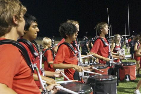 Members of the drum line, including sophomore Anthony Peterson, perform on the sidelines at a home football game.