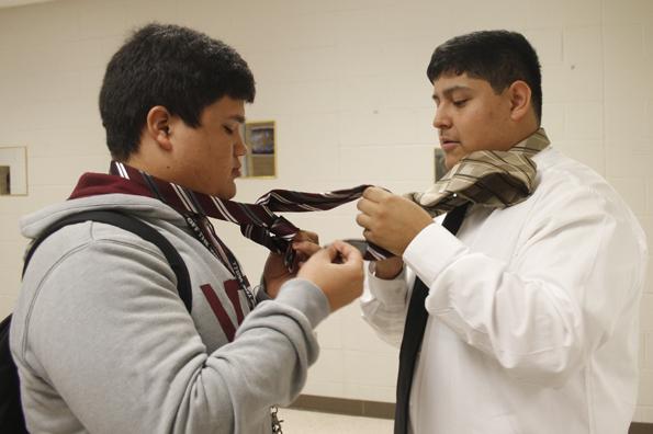 Seniors David Morales and Men of Tomorrow member, Marco Rivera go through the steps of tying a tie.