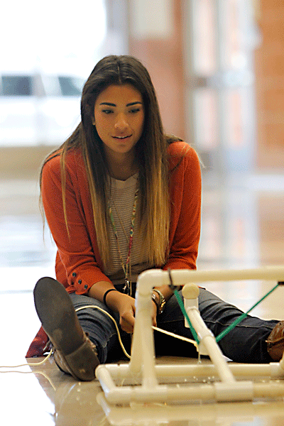 In Mr. Daviss AP Physics I class Oct. 28, Gabby Arguijo, 11, launches her catapult in the foyer. The objective was to launch the ball a distance eight to 10 times the length of the catapult. Arguijos ball went 12 times the length of her catapult. (Maddy Brown photo) 