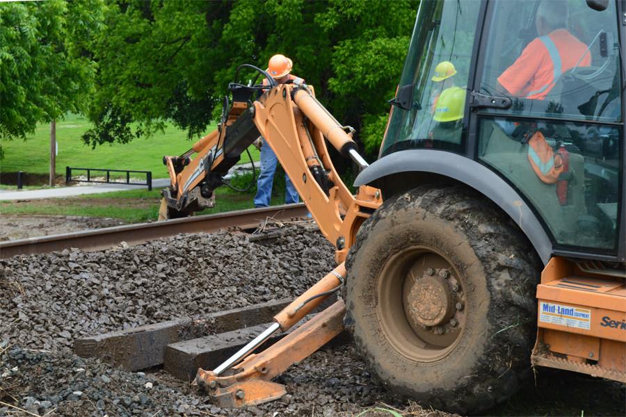 Union Pacific workers use a backhoe to move gravel underneath the vulnerable railway.
