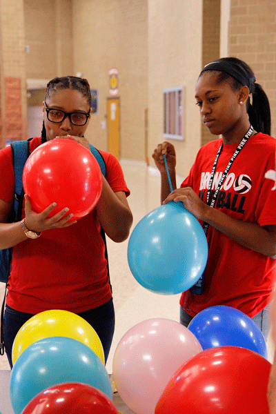 In Mrs. Daniels Teen Leadership class, Donsha Davis, 12, and Kelcy McHenry, 11, blow up balloons to create a tower. Students split into groups and had 30 minutes to make the tallest tower possible. (Maddy Brown photo)