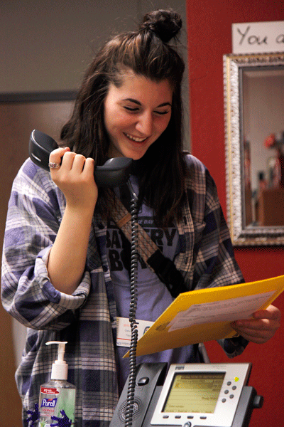 Gabby Taylor, 12, reads the daily announcements on the P.A. system in the third floor AP office.  (Maddy Brown photo)
