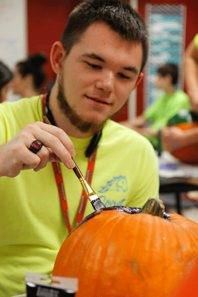 Baron Kane, 12, paint a pumpkin in StuCo for Halloween decorations on Oct. 28. (Maddy Brown photo)