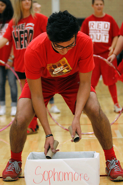 At the Red Out pep-rally, Peter Contreras, 10, tries to throw toilet paper rolls in a hula hoop for the class competition. The senior class won the competition, beating the teachers by one point. (Maddy Brown photo)