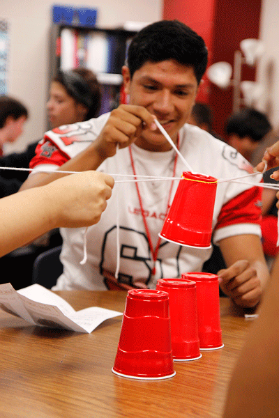 Adrian Jimenez, 12, builds a cup tower in Mrs. Daniels Teen Leadership class. Students attempted to build the tallest tower only using a rubber band and pieces of string. (Maddy Brown photo)