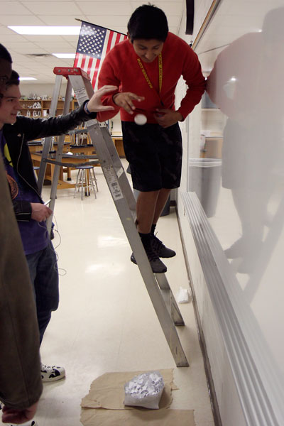 In Mr. Wildes Physics class, Mario Torres, 11, drops a raw egg from various heights into a paper crate his group built in attempt to keep the egg from cracking. The objective was to build the best crate to reduce the harsh impact and protect the egg. (Tapanga Perrin photo) 