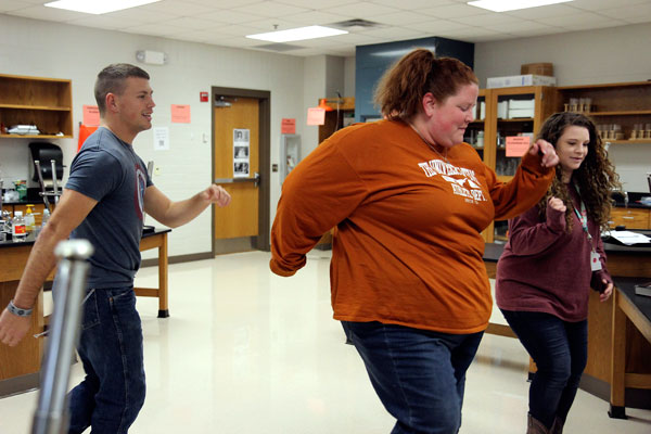 Ms. Morgan Harrell dances to the Footloose soundtrack with Robert Hawes, 12, and Kaylee Mitchell, 12, on Jan. 14 in Biology class. (Aisha DeBurr photo)