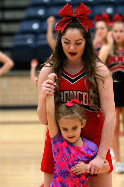 In the Varsity gym, Cami Epperson, 10, helps a aspiring cheerleader learn a cheer on Dec. 12 at the Legacy Cheer Clinic. (Megan Bell photo)