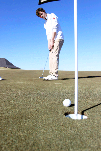 Holden Ross, 10, putts the ball into the hole on Feb. 11 at golf practice. (Aisha DeBurr photo) 