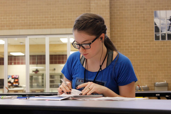 After her Ben Barber session in the afternoon, Meghan Simoneau, 10, works on AP World History homework in the cafeteria. 