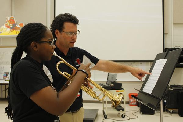 Mr. Shadman helps student in band