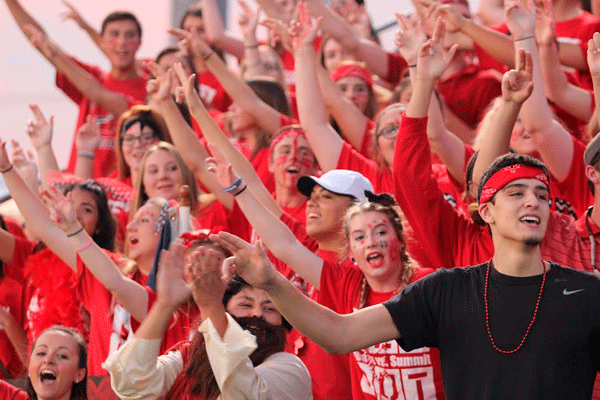 Ben Ritter, 12, cheers with friends in the student section at the football game against Summit. 