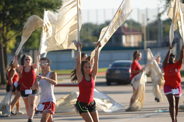 Color Guard practices with the band in the parking lot.