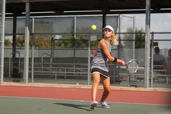 Lauryn Kerr returns the ball at the base line in a varsity Tennis match.