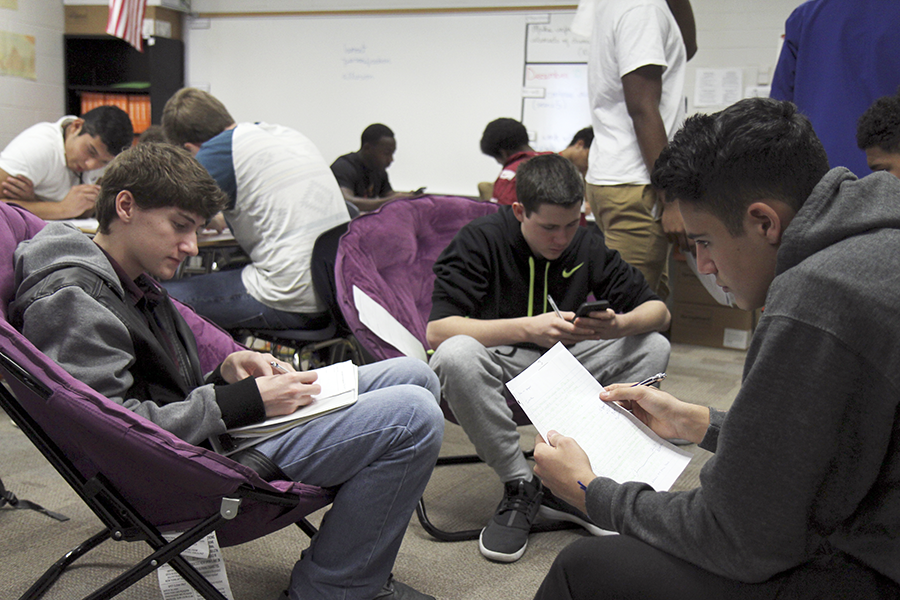 Men of Tomorrow students look over classwork in Mr. Browns English class.