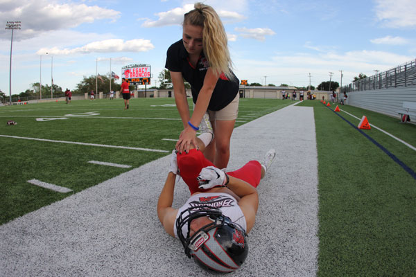 Erin McTighe, 12, assists an athlete during the Lovejoy football game. 
