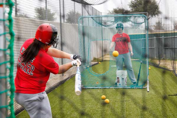 Lindsey Werner, 11,  hits front toss in the cages while teammate Stephanie Lewis, 10,  pitches to her. 