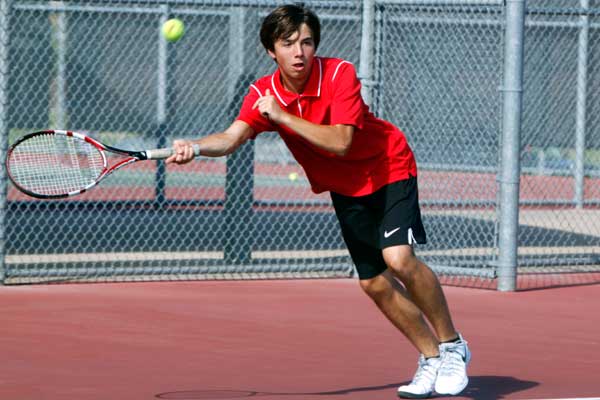 Mason Calloway, 9, returns the tennis ball to the opposing side. 