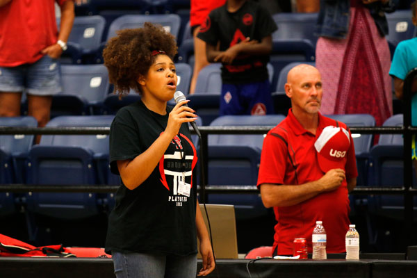 Nyah Buckrham, 12, sings the national anthem at a volleyball game. 