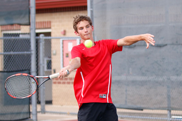 Josh Hogue, 12, hits a forehand while warming up for one of his varsity tennis matches. 