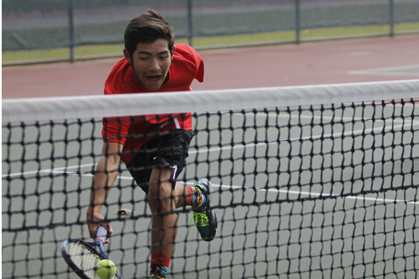 Josh Lopez, 11, attempts to return a low swing at a tennis match against Lake Ridge.