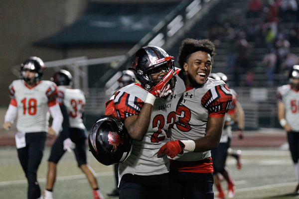 Marcus Fricks, 12, and Carlon Eggins, 11, rejoice after defeating Waxahachie with a 45-33 score at the game on Oct. 14. 
