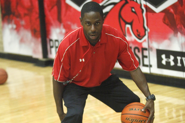 Head Boys Basketball Coach, Cornelius Mitchell, dribbles a basketball in the main competition gym.