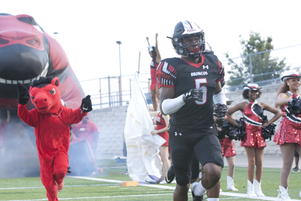 Jalen Catalon, 10, runs out with his team at a football game. 