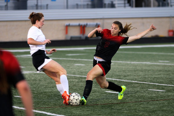 Kamryn Blevins, 10, kicks the ball from the defender at the first round playoff game against Granbury High School. 