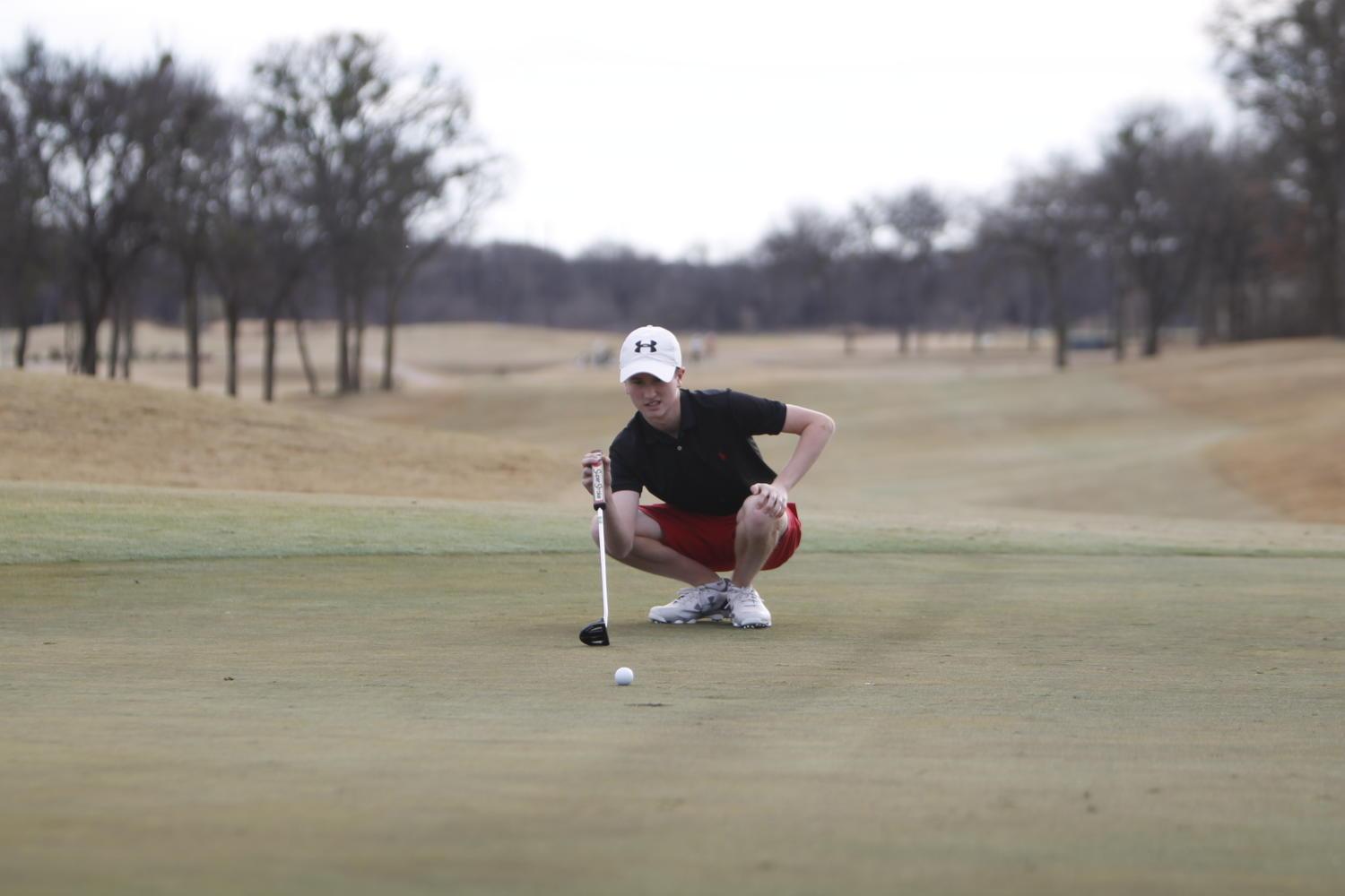 Clayton Waddell, 10, analyzes the green before making his shot. 