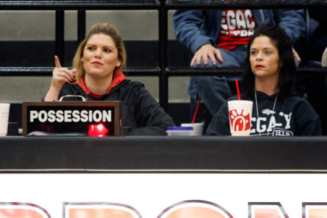 Ms. Jayme Schroeder and Dana Vorsino engage in a basketball game while managing the scoreboard. 