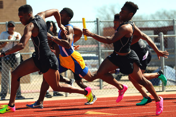 Jais Smith, 11, gains possession of the baton form his teammate Trent McDonald, 12.  