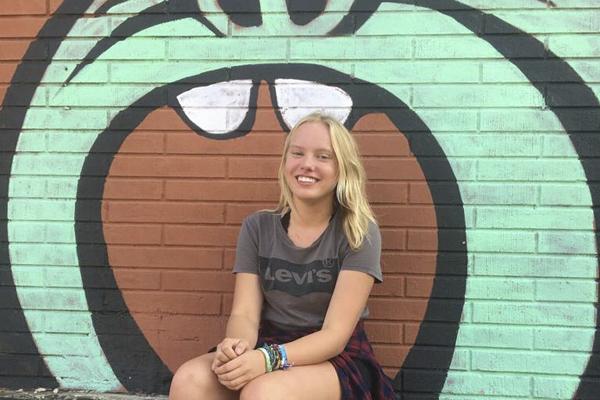 Zoe Menzel, 11, poses in front of a mural in downtown Mansfield.