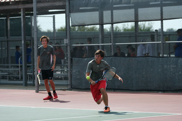 Junior Mason Callaway plays with his doubles partner, junior Zach Carpenter, at the varsity tennis match against Midlothian on Aug. 29. 
