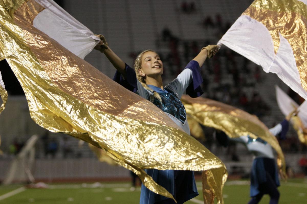 Kaymin Edwards, 12, performs at the varsity football game during halftime. Edwards performed with the other color guard members at Lancaster. (Ellie Brutsche photo)