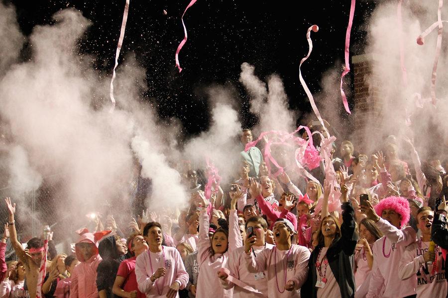 Students support the football team at Pink Out 2016 against Lake Ridge by throwing streamers and flour in the stands.