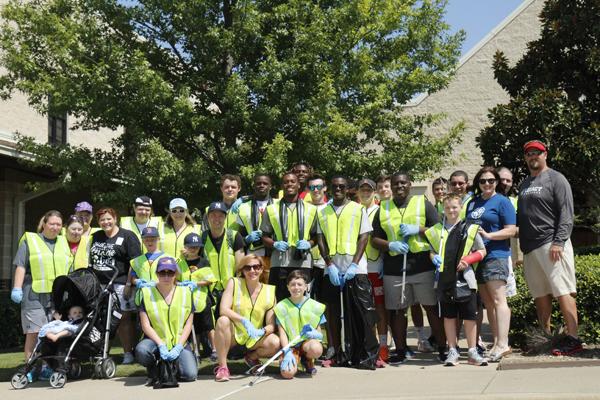 Coach Gary Ferguson and his wife Amanda pose for a photo with members of the football team and other volunteers after leading a service project with First Methodist Mansfields special needs department. Amanda received a diagnosis of a rare form of bone cancer in August before school started.