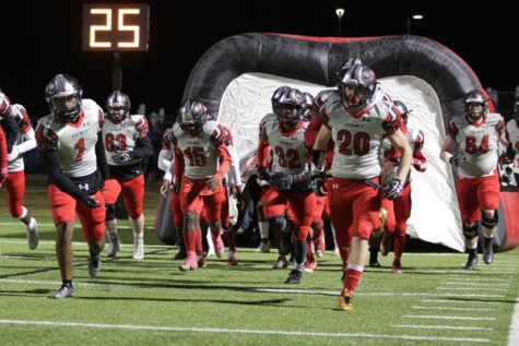 Senior Justin Oshields (#20)  runs out of the tunnel prior to varsity footballs match against Lake Ridge on Oct. 27.  The first round of playoffs will be on Nov. 17. 