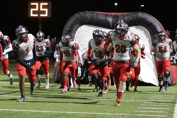 Senior Justin O'shields (#20)  runs out of the tunnel prior to varsity football's match against Lake Ridge on Oct. 27.  The first round of playoffs will be on Nov. 17. 