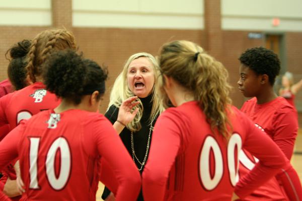 Head Coach Michelle Morris discusses plays with the girls varsity basketball team during their game against Summit. 