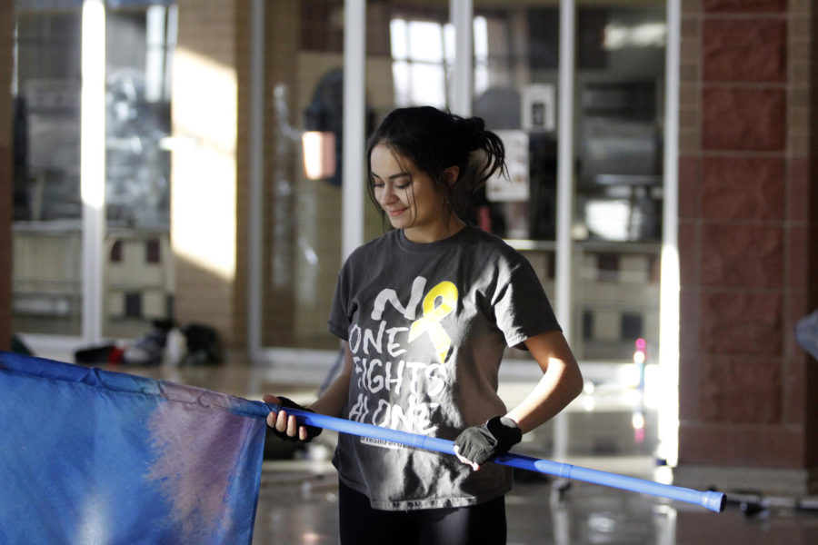 Senior Carissa Chavarria practices in the cafeteria for the first Winter Guard competition .