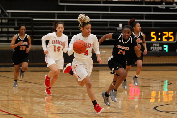 Harmoni Turner, 10, takes the ball down the court during the Broncos match against Lancaster on Jan. 26.