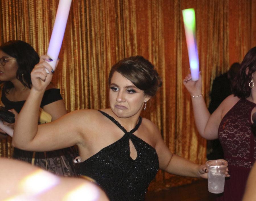 Lindsey Blakely, 12, dances in the center of a circle at prom. The DJs handed out glowing foam noodles after awards were given out. (Ellie Brutsché photo)